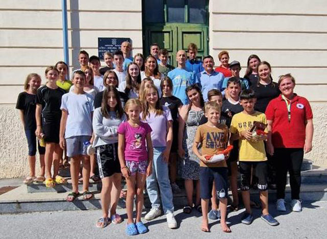 Ukrajinska djeca s domaćinima na ulazu u Dom                                                                                                                                                                                                              